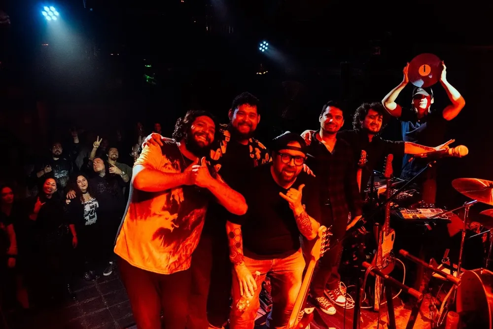 La banda completa celebrando en el escenario con el público