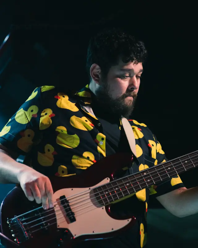 PatoParick tocando bajo con camisa de patos